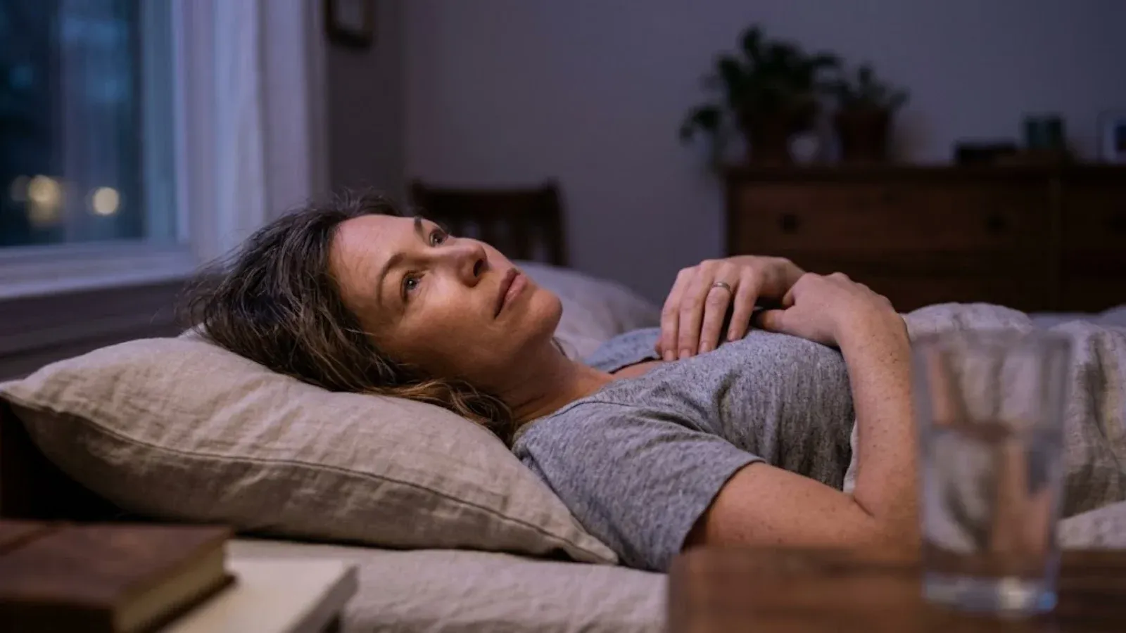 A woman lying awake in bed at night