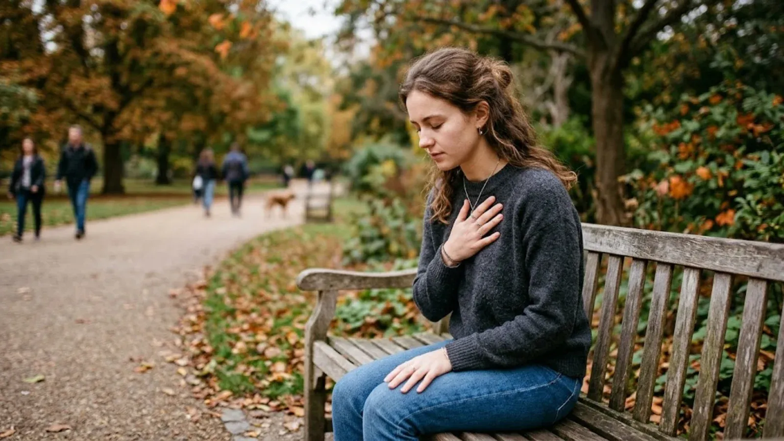 A young woman on a park bench breathing slowly to steady herself