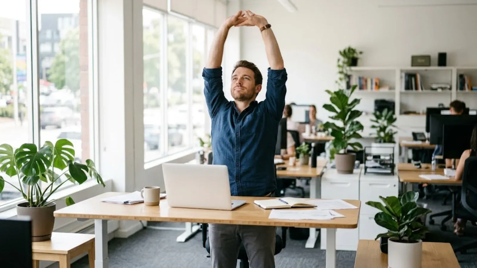 A man taking a short stretch break at his desk